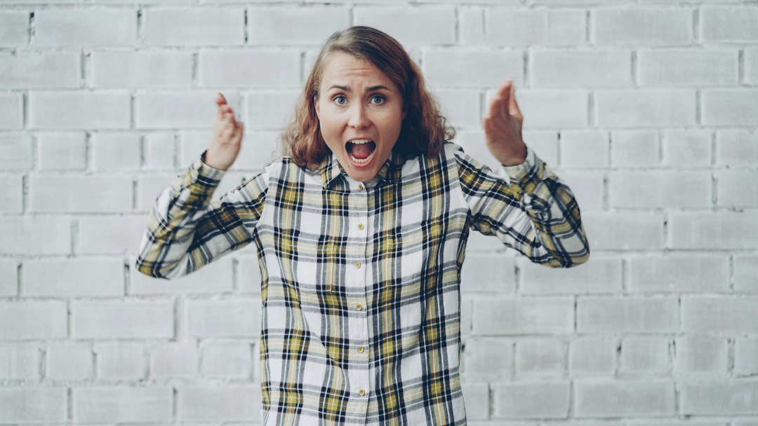 Woman with hands raised shouting in frustration